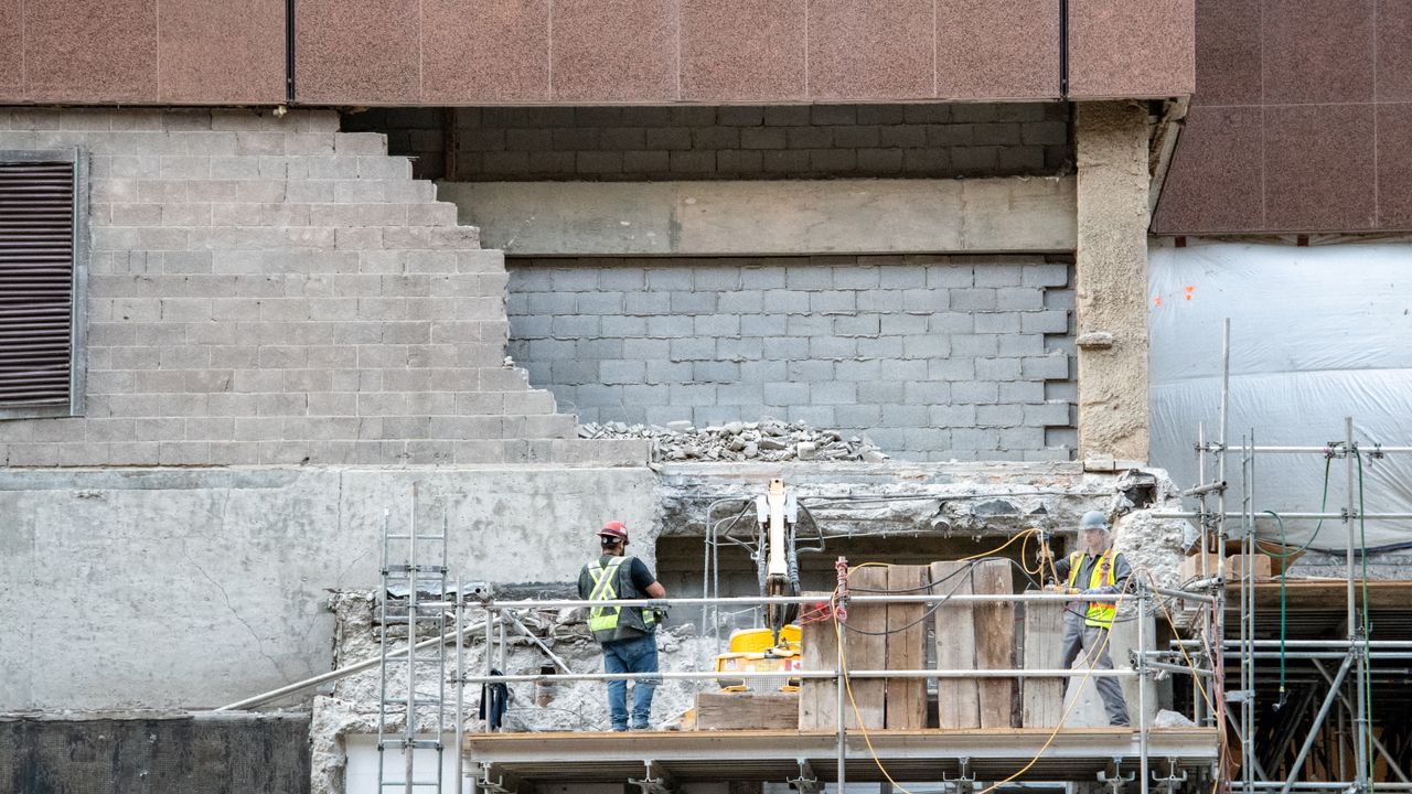 Des ouvriers du bâtiment sur des échafaudages sur un site de construction dans un développement urbain.